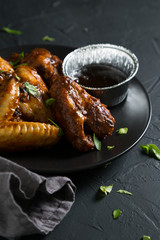 Fried chicken wings with sauce and chopped herbs