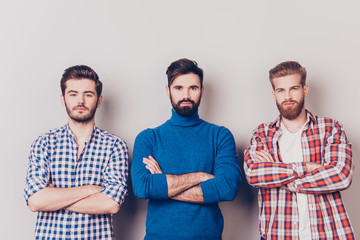 Ethnicity, multicultural diversity. Three serious harsh men are standing isolated on pure...