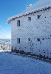 frozen house in winter mountain landscape