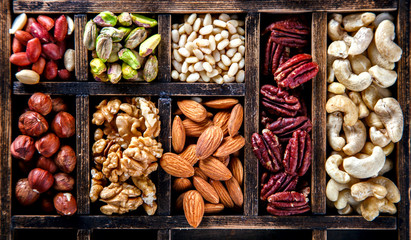Nuts Mixed in a Wooden Vintage Box.Assortment, Walnuts,Pecan,Peanuts,Almonds,Hazelnuts,Macadamia,Cashews,Pistachios.Concept of Healthy Eating.Vegetarian.selective focus.