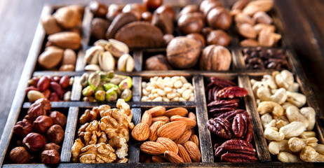 Nuts Mixed in a Wooden Vintage Box.Assortment, Walnuts,Pecan,Peanuts,Almonds,Hazelnuts,Macadamia,Cashews,Pistachios.Concept of Healthy Eating.Vegetarian.selective focus.