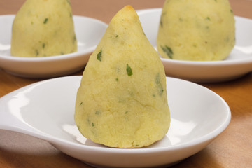 Traditional Brazilian snack called coxinha with one cut in diet version made of sweet potato