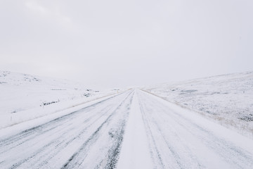 Snowy empty driving road in the winter Iceland