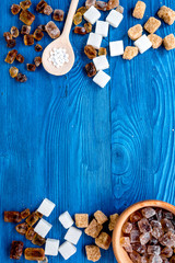 lumps and sanding sugar for sweets on blue kitchen table background top view mock up