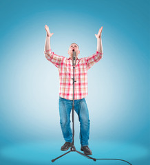 Studio portrait of a young showman with the microphone