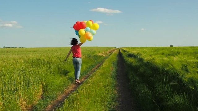 Happy girl with balloons. Girl with balloons in nature.