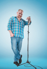 Studio portrait of a young showman with the microphone