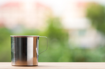 Stainless cup on wooden table.