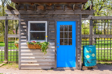 Fototapeta na wymiar Rustic garden shed with bright blue door