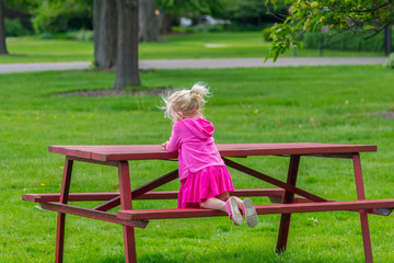 Little blonde girl at picnic bench