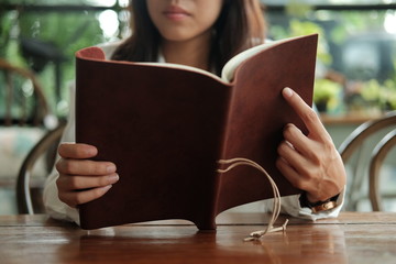 close up. young student woman sitting at library and reading book prepare for exam. image for business,education,book,people and portrait concept