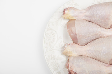 Close-up of pile of raw chicken thighs isolated on dish. Copy space.