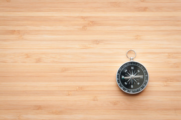 Compass on wooden table.