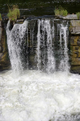 Fototapeta na wymiar Small waterfall in rocks with foam