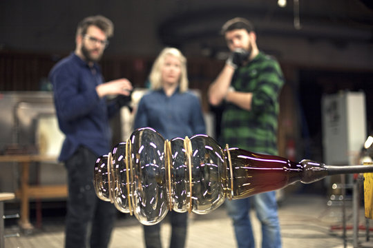 Glassblowers examining finished glas object