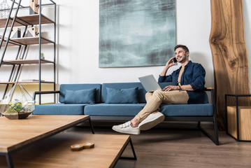 Happy youthful businessman making freelance work at his room