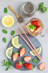 Healthy detox chia seed drink with strawberry, lemon and mint in glass jar, top view