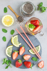 Healthy detox chia seed drink with strawberry, lemon and mint in glass jar, top view