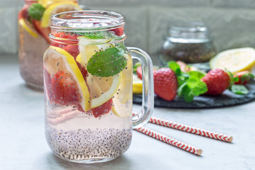 Fototapeta na wymiar Healthy detox chia seed drink with strawberry, lemon and mint in glass jar, horizontal