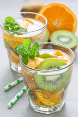 Healthy detox chia seed drink with kiwi, orange and mint in glass, vertical