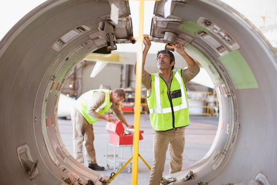 Aircraft workers checking airplane part