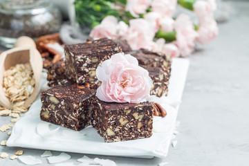 Paleo chocolate energy bars with rolled oats, pecan nuts, dates, chia seeds and coconut flakes, horizontal, copy space