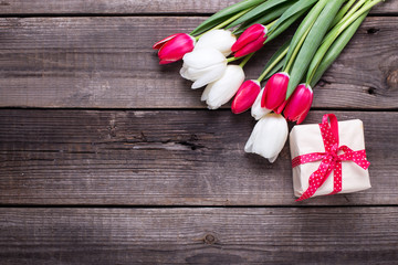 Box with gift  and bright  spring  tulips flowers on rustic wooden background.  S