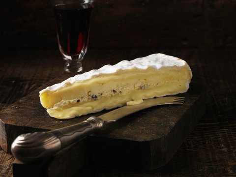 Slice of brie cheese on wooden board