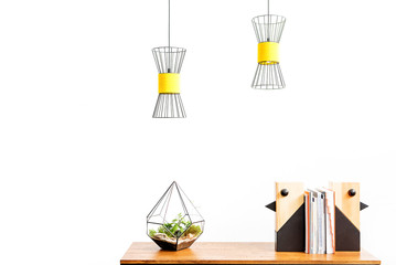 Flowerpot and statuettes for room setting with papers on desktop