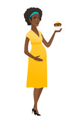 Pregnant woman holding a cupcake.