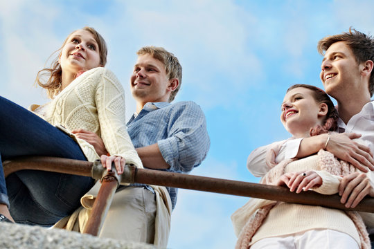 Couples standing at railing outdoors