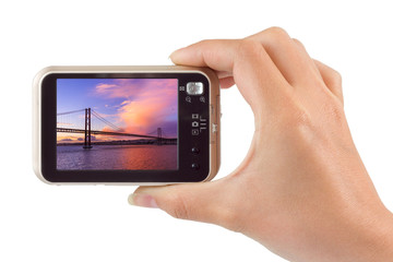 Hand with camera and 25th of April Bridge - Lisbon Portugal (my photo)