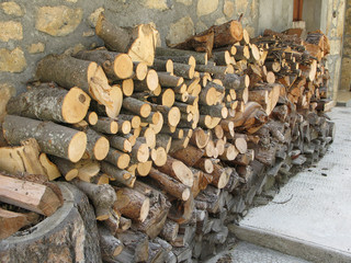 Pile de bois de chauffage devant une maison de village