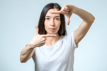 Attractive young woman using her hands to create a border