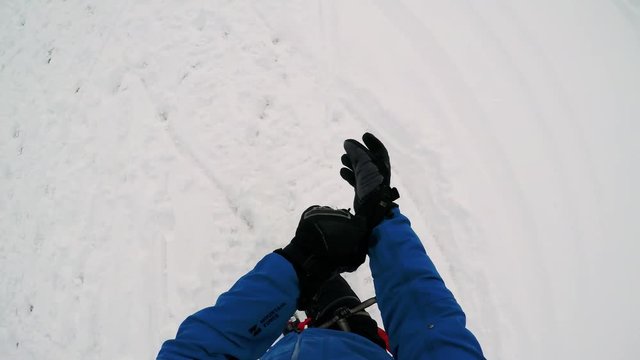 Man skier walks in winter and he puts on winter gloves - first person view