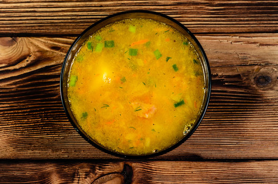 Vegetable soup in a glass bowl on wooden table. Top view