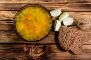 Vegetable soup in a glass bowl on wooden table. Top view