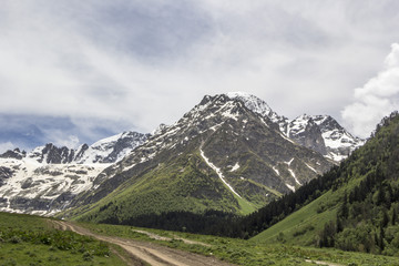Fototapeta na wymiar Горный пейзаж, красивый вид на живописные горные склоны, панорама горного ущелья, белые облака на небе, дикая природа и горы Северного Кавказа