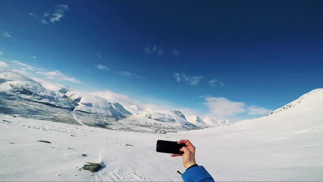 Man skier takes a selfie photo of himself on the mountain - sunny day - pov