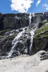 Fototapeta na wymiar Красивый вид на мощный водопад в горном ущелье, живописный пейзаж, дикая природа Северного Кавказа
