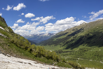 Obraz premium Górski krajobraz, piękny widok na malownicze górskie stoki, panorama górskiego wąwozu, białe chmury na niebie, bezdroża i góry Kaukazu Północnego