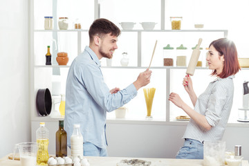 Funny Couple in love cooking dough and having fun with flour in  kitchen