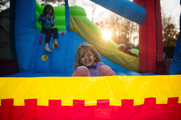 Children, outdoors, playing on bouncy castle