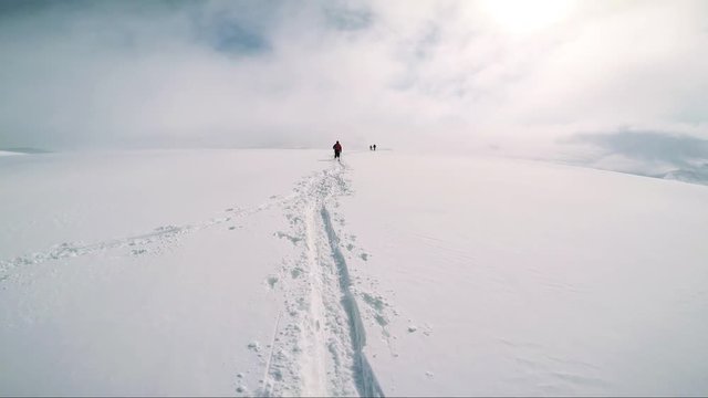 Man skier walks on ski with friends in the middle of mountain - sunny day - pov