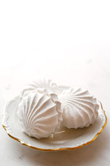 Meringues on a plate. White background. Copy space