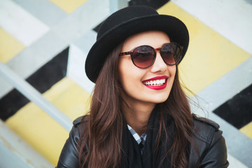 Young stylish woman in a city street drinking coffee .