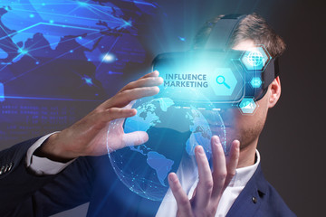Business, Technology, Internet and network concept. Young businessman working on a virtual screen of the future and sees the inscription: Influence marketing