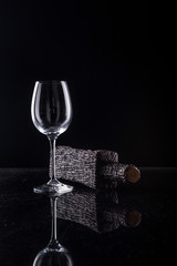 Wine bottle with a glass on a black background