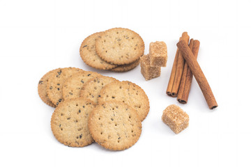 Biscuits, cane sugar, cinnamon sticks on white background