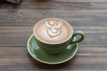 Cup of hot coffee latte with beautiful style on wood table